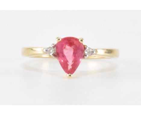 A hallmarked 9ct gold pink sapphire and diamond ring. The ring being set with a pear cut pink sapphire flanked by two round c