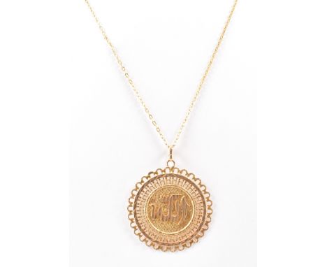 A Persian Iranian gold pendant necklace. The pendant having a medallion with arabic lettering to the centre and pierced detai