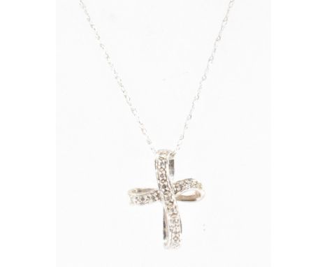 A white gold cross pendant and necklace. The cross pendant of curved form being set with white stones on a fine link chain. P