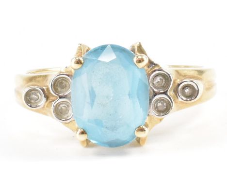 A hallmarked 9ct gold blue stone ring. The ring being set with a central oval blue stone, each shoulder flanked by three smal