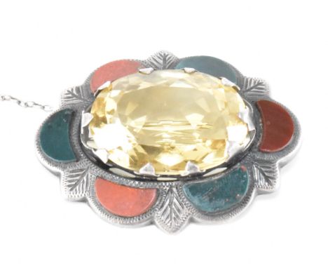 A Scottish silver hard stone and citrine brooch with safety chain. The brooch having set polished semi circle hard stone and 