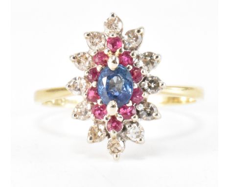 A vintage gold sapphire, ruby and diamond cluster ring. The ring having a navette shaped head with an oval cut blue sapphire,