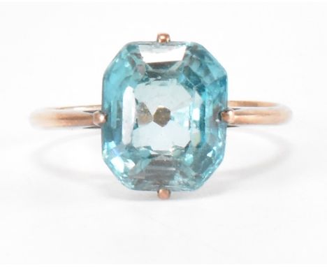 An early 20th century blue zircon rose gold ring. The ring having an emerald cut zircon stone on tapered plain gold shoulders