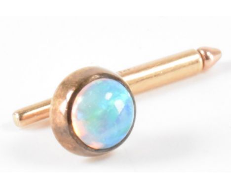 A vintage gold and opal tie pin. The pin being set with a round opal cabochon on a gold bar with retracting pin. The pin mark