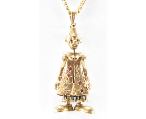 A hallmarked 9ct gold clown pendant necklace. The necklace having a flat link chain with an articulated clown pendant set wit