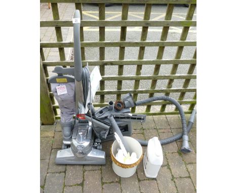 Vintage Kirby vacuum cleaner with attachments and cleaning products, including a Kirby carpet first aid kit, service records 
