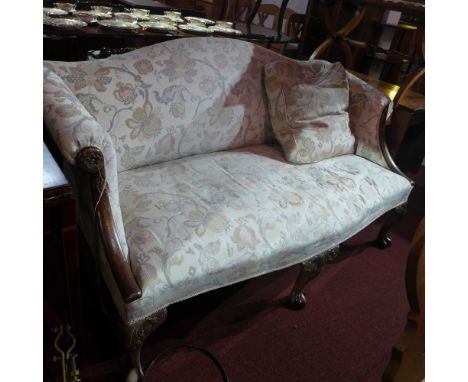 A Georgian style mahogany sofa upholstered in floral pale fabric and with carved detail raised on scrolling ball and claw sup