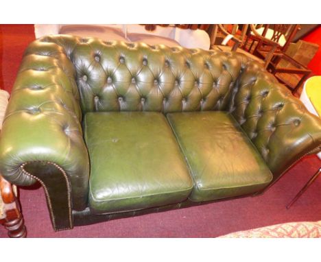 A Chesterfield two seater sofa upholstered in buttoned green leather 