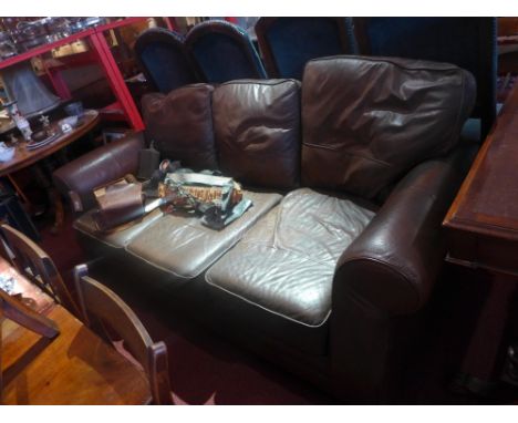 A contemporary designer three seater sofa upholstered in brown leather