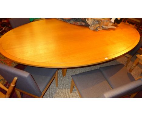 A contemporary designer dining table of large size, the light oak oval top raised on tapering supports