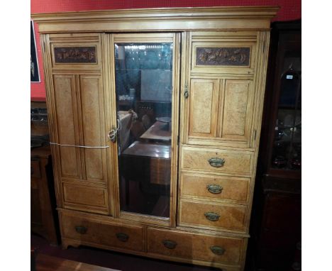 A Victorian light oak and pollard oak triple wardrobe fitted arrangement of panel doors and drawers by Crosby and Sons on pli