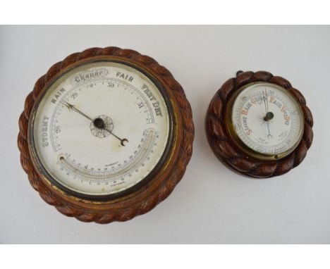 A barometer with intergrated thermometer. Golden oak case. White dial with brass hand. Diameter 22cm, together with another b