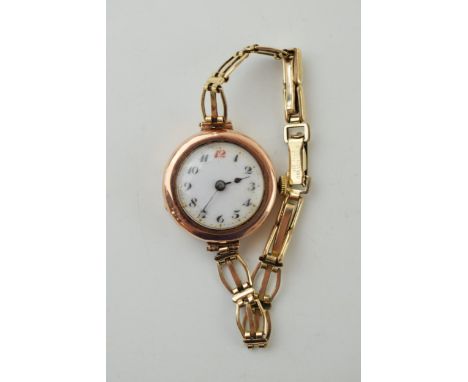 9ct gold ladies wristwatch with white enamel dial and arabic numerals, working, rolled gold strap, gross 16.9g.  