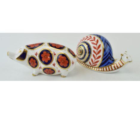 Royal Crown Derby paperweights in the form of an imari pig and a garden snail, both first quality, ceramic stoppers (2).  In 