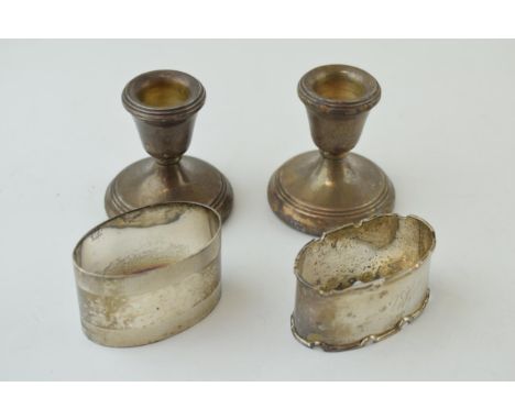 Silver to include two singular napkin rings, 54.0g, with a pair of small pair of silver short candlesticks, Birmingham 1982, 