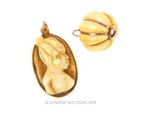 Two, 18 ct yellow gold and bone, vintage, West African, pendants, to include a ribbed, spherical bone pendant with yellow gol