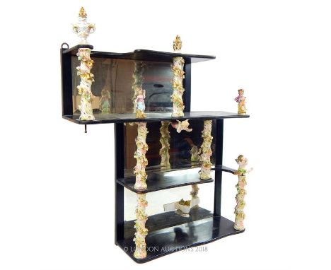 An unusual, mirror backed hanging shelf with floral porcerlain supports and figures.