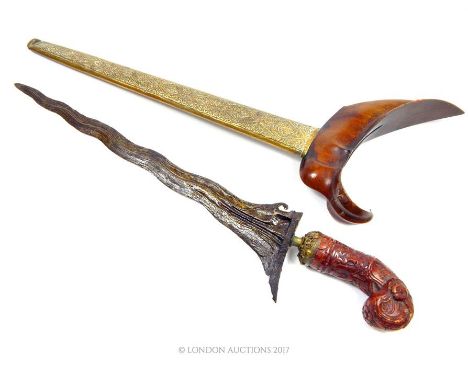 A 19th century, Malay, 'kris' dagger with a very finely carved handle, opens to reveal a roughly cast, waved blade, a brass h