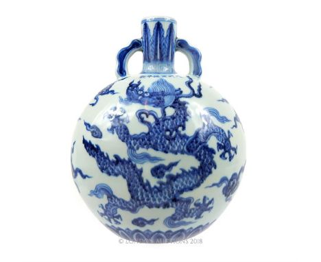 A Chinese, hand-painted, blue and white, moon flask with a a blue, scaled dragon chasing the flaming pearl on each side and s