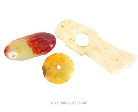 Three Chinese jade items including an axe head, 13 x 5cm, a disc, 4.5cm diameter, and a pendant, 7.5 x 3.5 x 1.5cm.