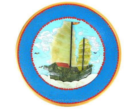 A cloisonne plate inlaid with a relief carved jade Chinese junk boat; 31cm diameter.