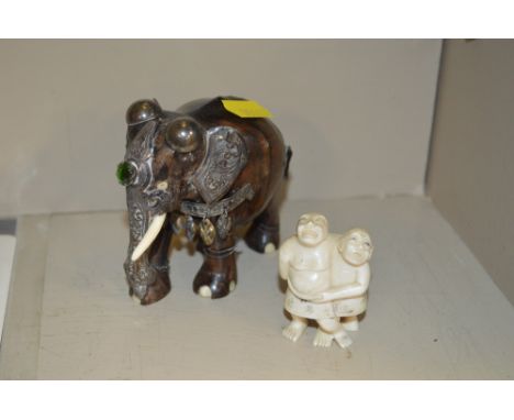 An Eastern and carved wooden white metal mounted elephant; and a ivory Netsuke