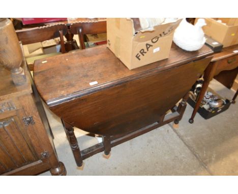 An antique oak gate leg dining table 