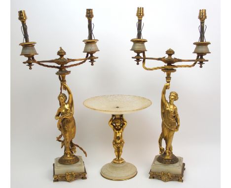 A pair of French gilt bronze figural candelabras modelled as classical women holding aloft torches and a gilded metal cherub 