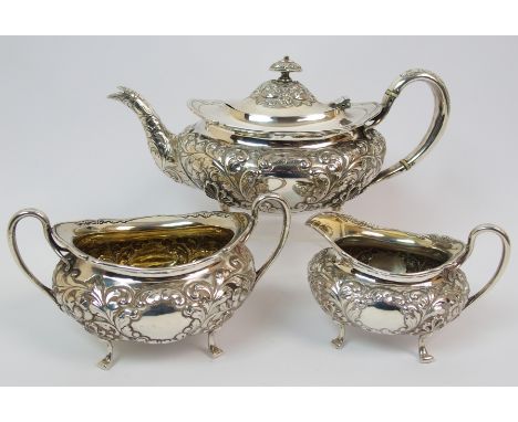 An Edwardian three piece silver tea service by James Weir, Glasgow, 1903, of squat oval form with foliate embossing and blank