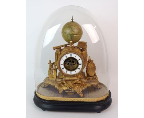 A French gilded metal mantle clock the case adorned with assorted items including a pile of books, a lyre, a laurel wreath, a