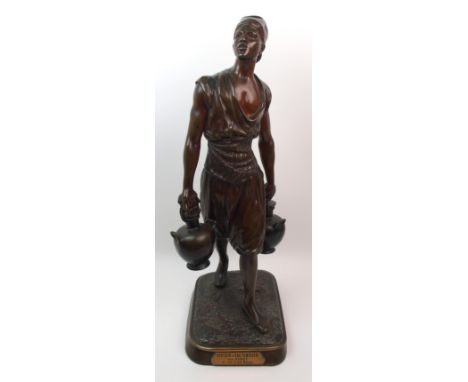 After Marcel Debut (1865-1933) Porteur d'eau Tunisien a cast bronze of a man, signed to base and with plaque to front, 62cm h