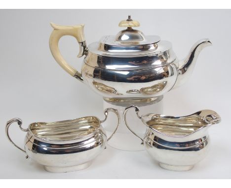 A three piece silver tea service by Emile Viner, Sheffield 1936, of oval bombe shape, the teapot with looping ivory handle an