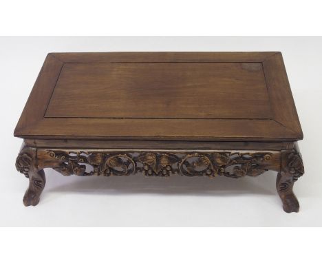 A Chinese hardwood low table with carved leaf and berry frieze and on scroll branch feet, 28cm high x 83cm wide x 47cm deep