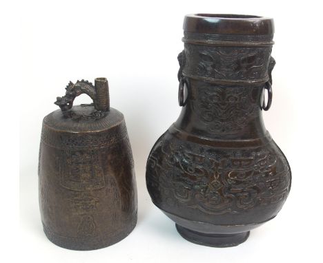 A Chinese bronze archaic style vase cast with taotie masks beneath a pair of animal mask ring handles, 29cm high and a bell c