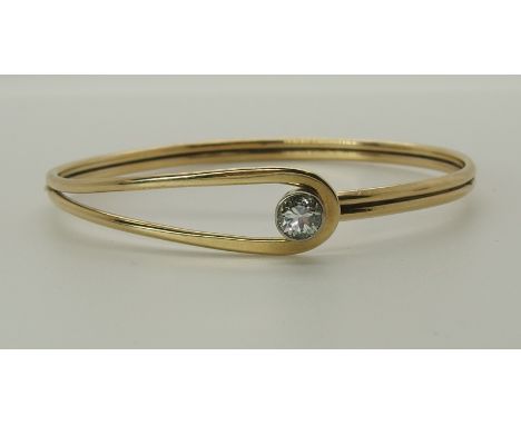 A 9ct gold hand made bangle set with a diamond of estimated approx 0.70cts, inner diameter of the bangle 6.1cm x 5.5cm, weigh