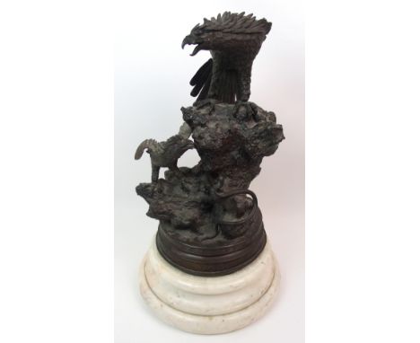 A Japanese bronze sculpture modelled with an eagle above young and a serpent, standing on rockwork, raised on a circular key 