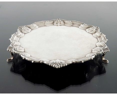 A George VI silver salver, William Hutton, Sheffield 1938, circular with ogee scroll and shell moulded fluted rim, on three d
