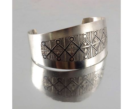 A Scandinavian Modernist white metal and enamelled bangle, circa 1970s, incised geometric design with black enamel trellis, 7