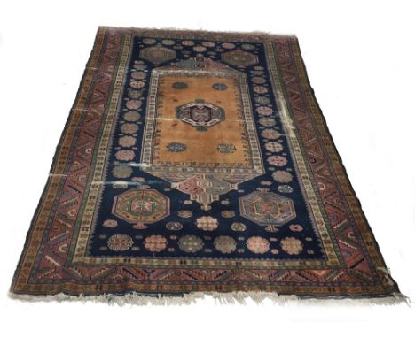 Antique Persian patterned navy ground carpet, decorated with central shield among flower head medallions within multiple geom