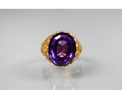 A 1970s yellow metal ring of sculptural design inset with oval amethyst, size O, stamped k18, approx 7.6g all in 