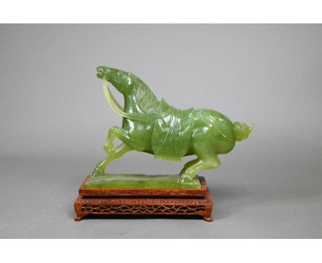 A 20th century Chinese 'new jade' bowenite carving of a Tang style horse c/w reticulated hardwood stand, 22 cm high 