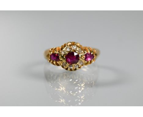 An antique ruby and diamond cluster ring, the central oval ruby surrounded by small eight-cut diamonds, with ruby-set shoulde