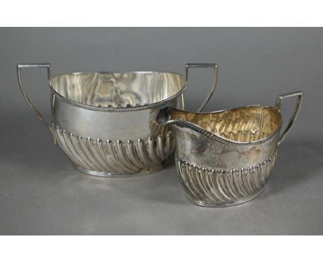 A late Victorian silver milk jug and sugar basin with gadrooned rims and writhen half-reeding, Harrison Brothers &amp; Howson