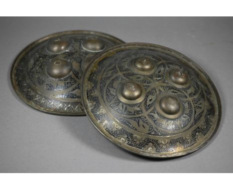 Two early 20th century Indo-Persian brass dhal shields, both of typical convex form with rolled edge, four domed bases and fl