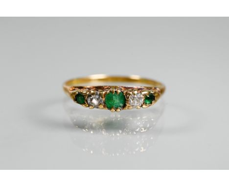 An antique emerald and diamond ring, the three graduated emeralds with two old cut diamonds alternately set, in yellow gold s