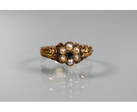 A Victorian cluster ring, the central cluster set with six small half pearls surrounding a single green garnet, with carved s