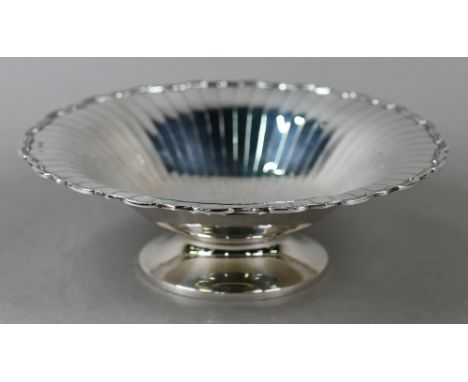 An Art Deco silver dish with radiating shallow flutes and moulded rim, on raised foot, Selfridge &amp; Co. Ltd., Birmingham 1