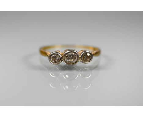 An antique three stone diamond ring, the graduated diamonds in bezel settings, yellow gold set (marks obscured), size Q Shank