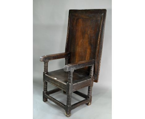 A Charles I jointed oak box-seat table-chair, circa 1640, having a pivotal boarded top/back with cleated ends over round-ende