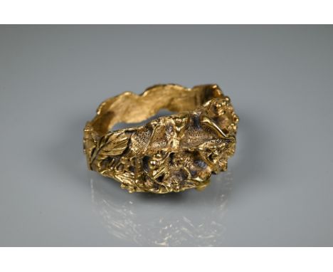 Trifari - A gilt metal bangle of sculptural naturalistic form, half hinged with concealed clasp, 6 cm diam Safety chain missi